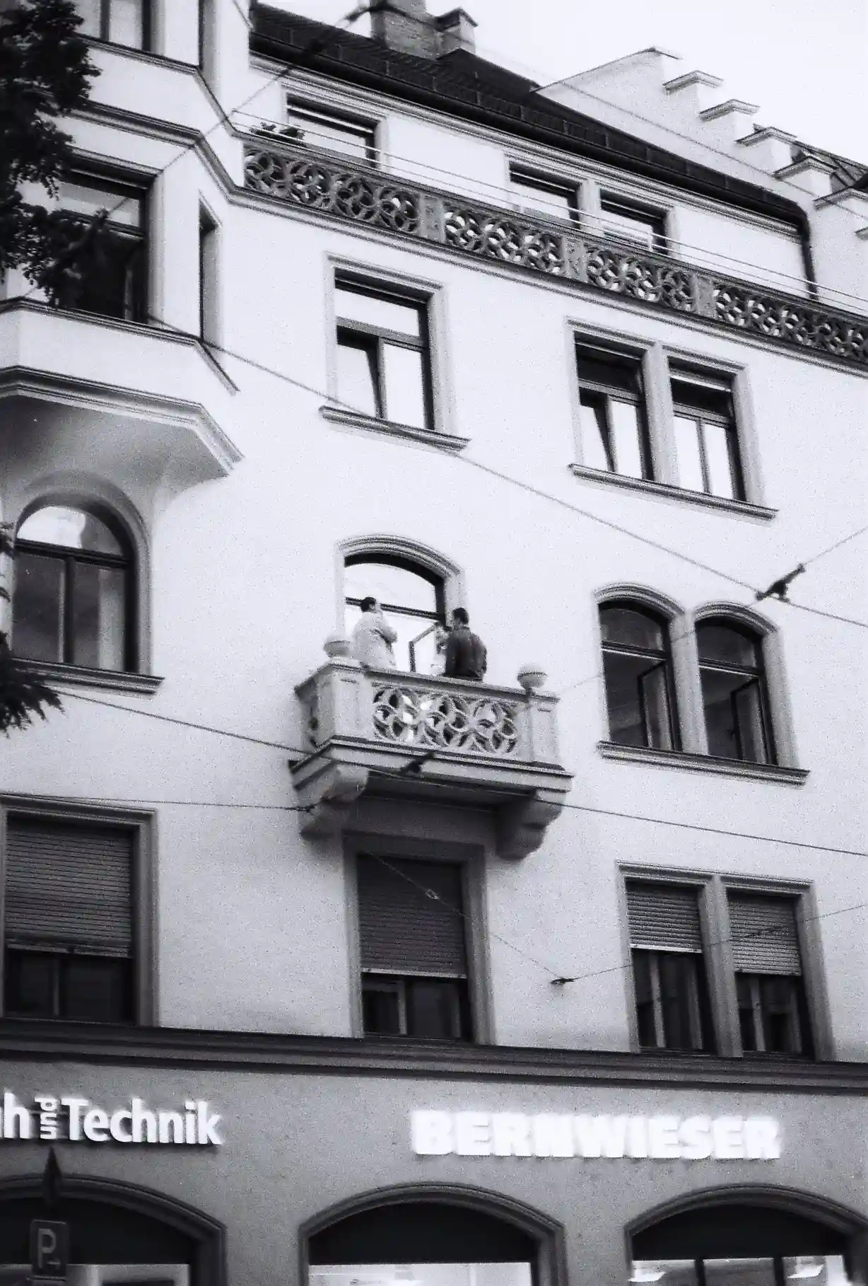 Two people standing on balcony munich Altbau