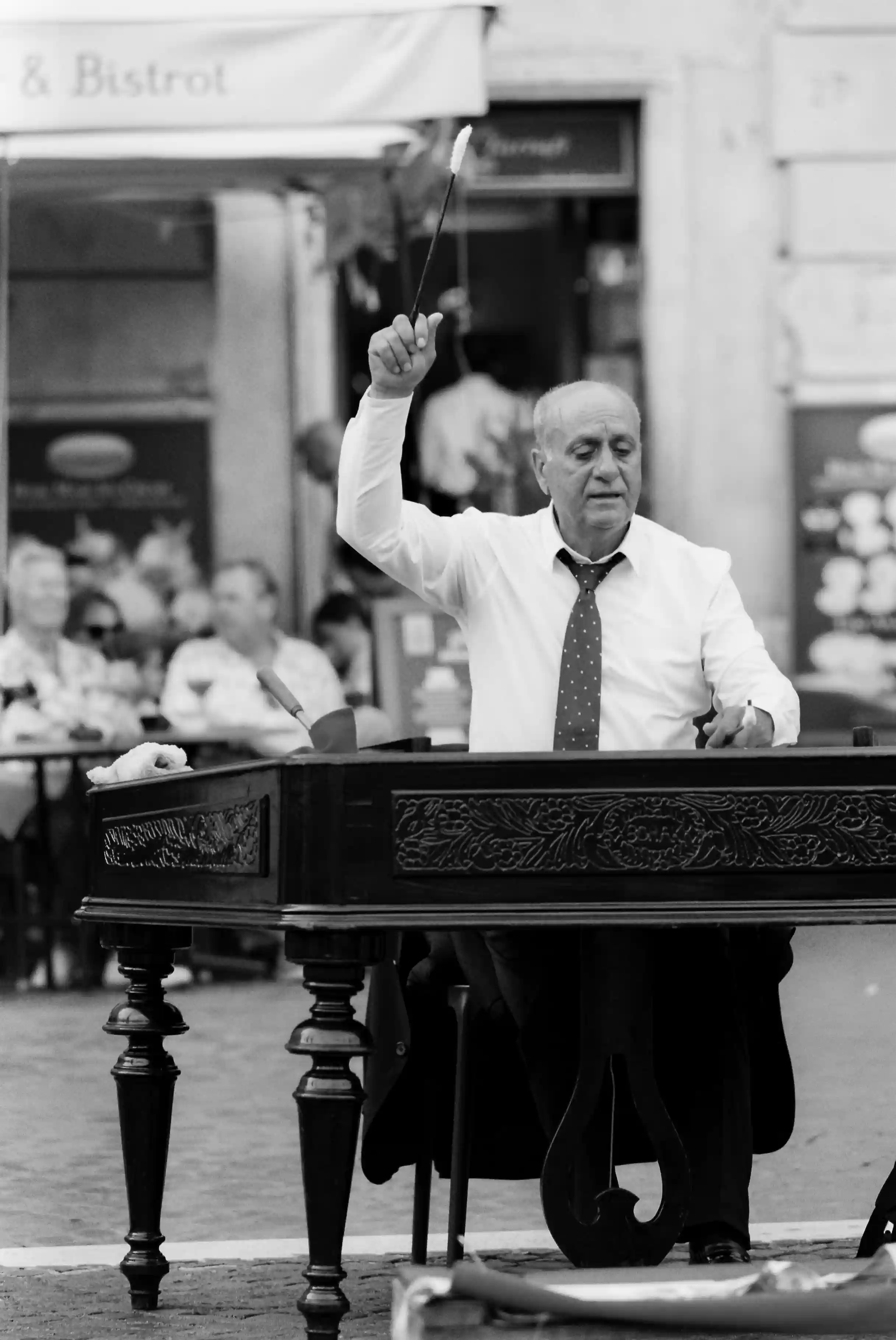 Old man playing instrument on streets black and white